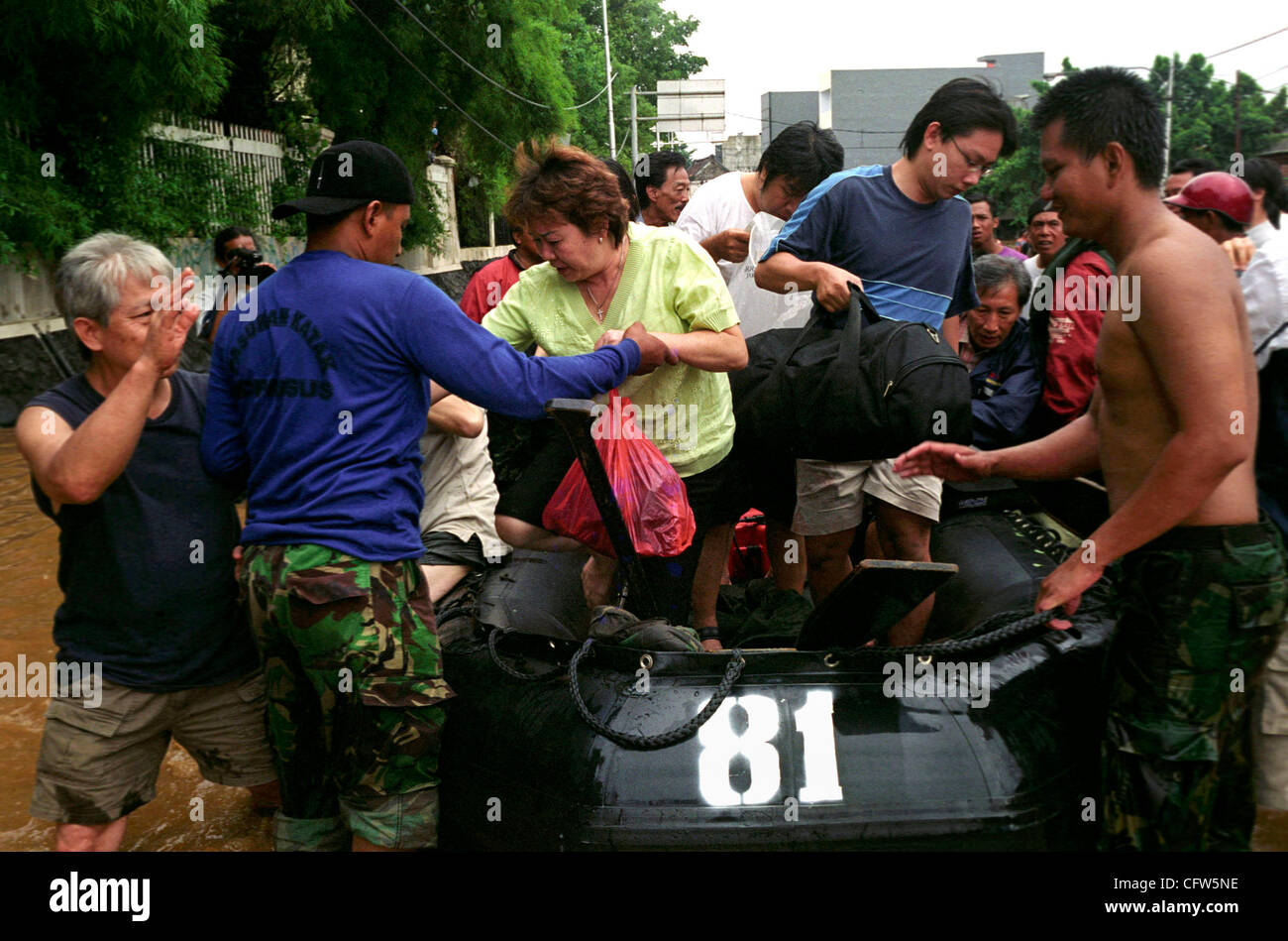 JAKARTA, Indonesia, 4 febbraio 2007: indonesiano Marines aiutare i residenti di Jakarta per ottenere fuori della barca dopo evacuarli dalle case inondate presso la principale area di business nel mercato Jatinegara. Grave tempesta ha causato inondazioni in Indonesia capitale, come fiume ha rotto le loro banche, intasano le strade migliaia di Foto Stock