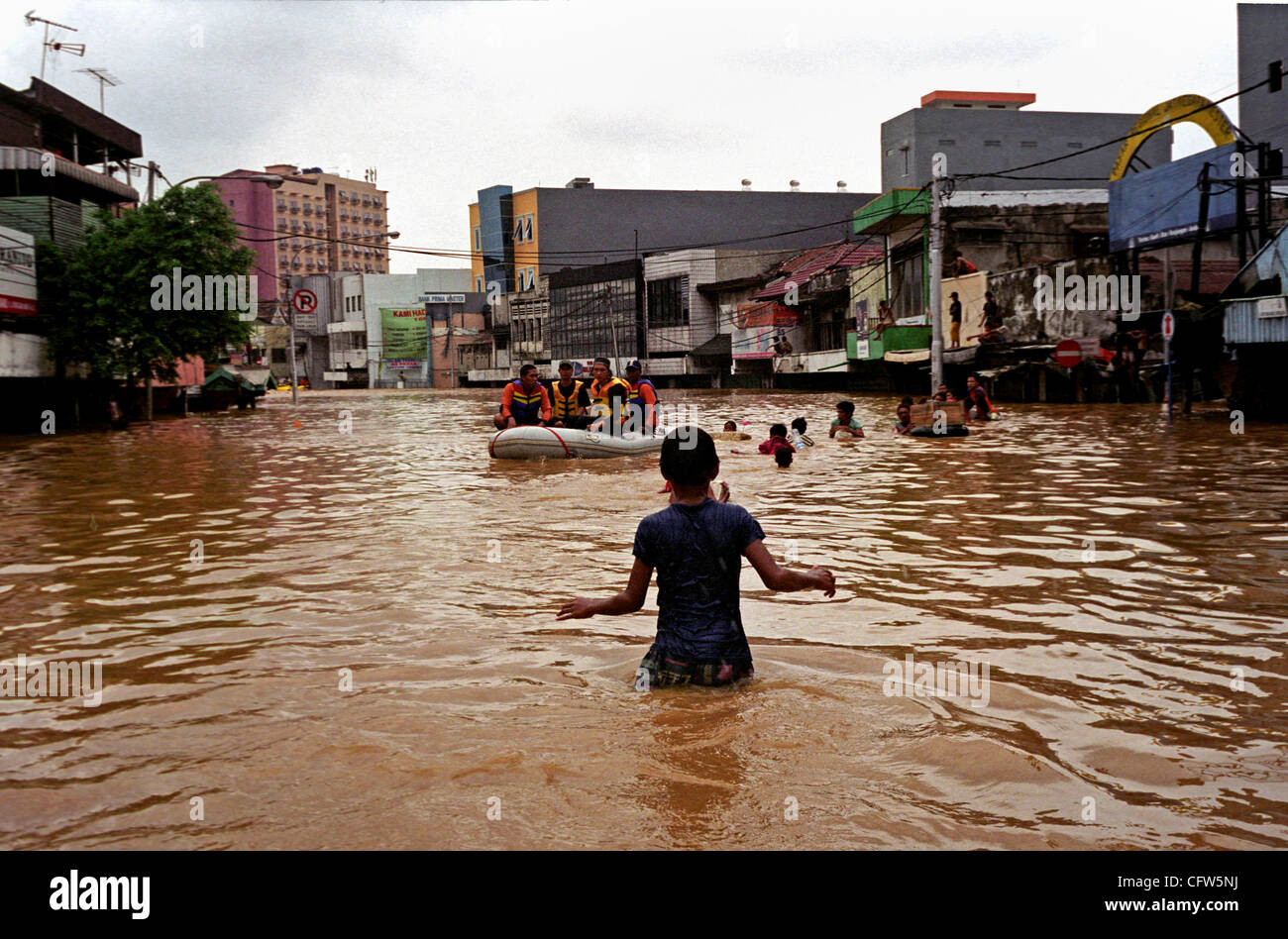 JAKARTA, Indonesia, 4 febbraio 2007: un battello in movimento come Jakarta residenti wade all'allagato street presso la principale area degli affari. Grave tempesta ha causato inondazioni in Indonesia capitale, come fiume ha rotto le loro banche, intasano le strade migliaia di case e di business. Foto di Edy Purnomo/JiwaFoto Foto Stock