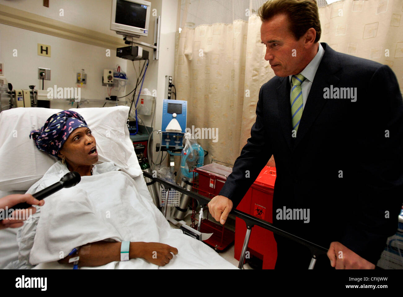 Aprile 17, 2007 San Diego, CA governatore Arnold Schwarzenegger, destro, viene interrogato dal paziente IVY HARRIS di sud-est di San Diego, a sinistra come egli tours la stanza di emergenza presso lo Scripps misericordia Ospedale San Diego il martedì pomeriggio per promuovere il suo piano di estendere la copertura assicurativa per l'assicurato. Sh Foto Stock