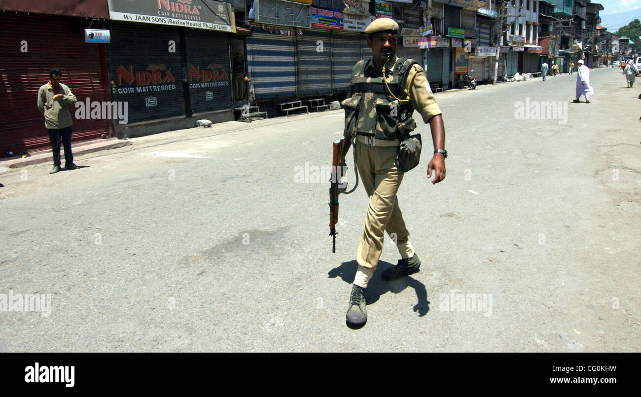 Una sicurezza indiano uomini cammina nei pressi di un mercato chiuso in Srinagar, India, venerdì 6 luglio, 2007. Negozi, le imprese e le scuole chiuse venerdì attraverso indiano-Kashmir controllata in risposta a uno sciopero da separatisti per protestare contro le presunte violazioni dei diritti umani perpetrate da forze di governo. Foto/ALTAF ZARGAR Foto Stock