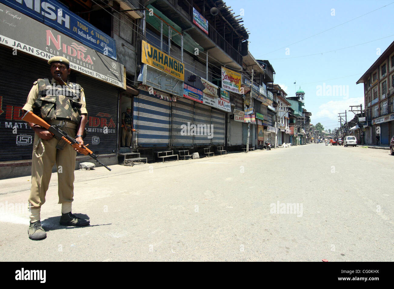 Un Indian uomini della sicurezza guardia vicino a una strada deserta in Srinagar, India, venerdì 6 luglio, 2007. Negozi, le imprese e le scuole chiuse venerdì attraverso indiano-Kashmir controllata in risposta a uno sciopero da separatisti per protestare contro le presunte violazioni dei diritti umani perpetrate da forze di governo. Foto/ALTAF ZARG Foto Stock