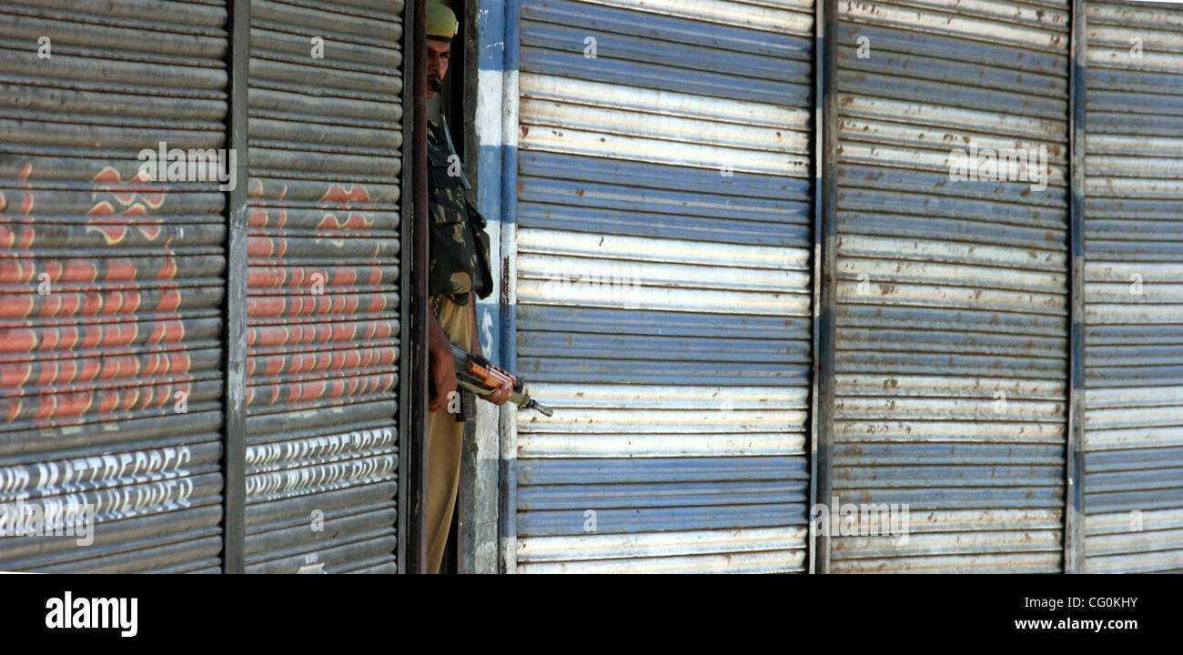 Uomini della sicurezza mantiene la veglia vicino mercato chiuso in Srinagar, India, venerdì 6 luglio, 2007. Negozi, le imprese e le scuole chiuse venerdì attraverso indiano-Kashmir controllata in risposta a uno sciopero da separatisti per protestare contro le presunte violazioni dei diritti umani perpetrate da forze di governo. Foto/ALTAF ZARGAR Foto Stock