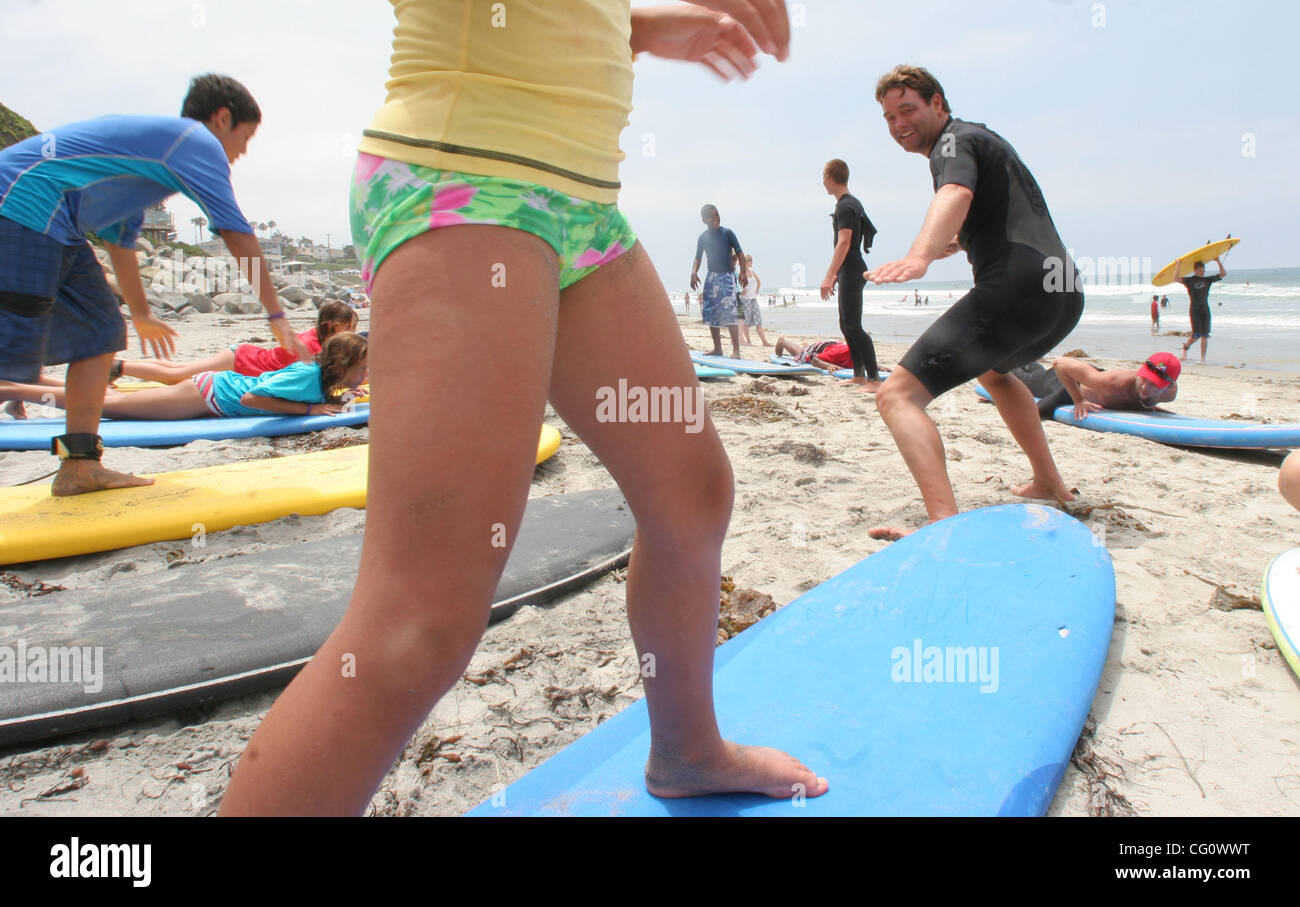 Luglio 16, 2007, la Costa, CA, Stati Uniti d'America_Matt bietole (destra in piedi) mostrava tè ( tilde oltre l'E) CECE (gambe) e NYKO HELSEL come per mantenere il loro equilibrio su una tavola da surf. I bambini di genitori militari sono stati invitati ad imparare a fare surf in spiaggia sotto la luna da un gruppo chiamato libertà non è libero. Obbligatorio Foto Stock
