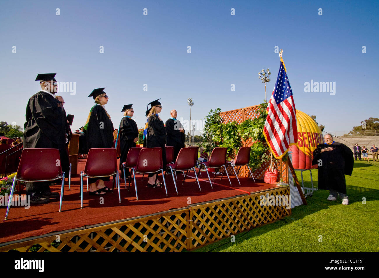 Alta scuola i membri di facoltà recitare il giuramento di fedeltà alla bandiera degli Stati Uniti durante gli esercizi di graduazione in Huntington Beach, CA. Foto Stock