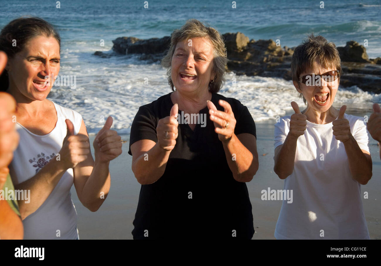 I membri di un "Risate Yoga Club' mostrano pollice in su approvazione di ogni altra che si incontrano in una località di mare in Laguna Beach, CA. Ritenendo che "la risata è la migliore medicina", essi si impegnano in risate per motivi terapeutica come divertimento. Modello di rilascio Foto Stock