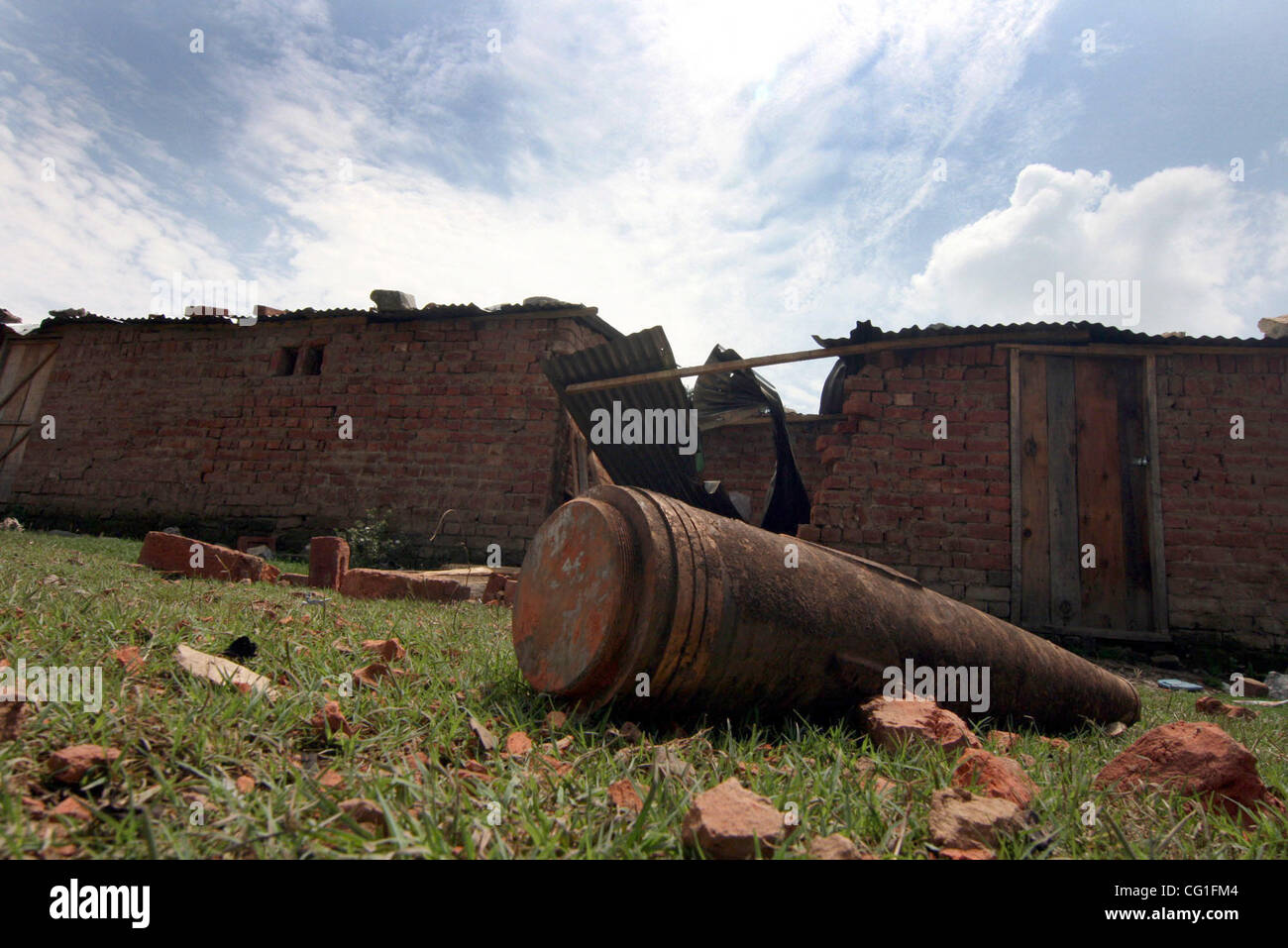 Una diffusa munizioni inesplose vicino a casa dopo un incendio in un esercito indiano deposito di munizioni in Khundroo, 90 km (56 miglia) a sud di Srinagar Agosto 11, 2007. Venticinque persone, compresi 10 soldati e 13 vigili del fuoco, mancano due giorni dopo un grande incendio scoppiato in un esercito indiano ammuniti Foto Stock