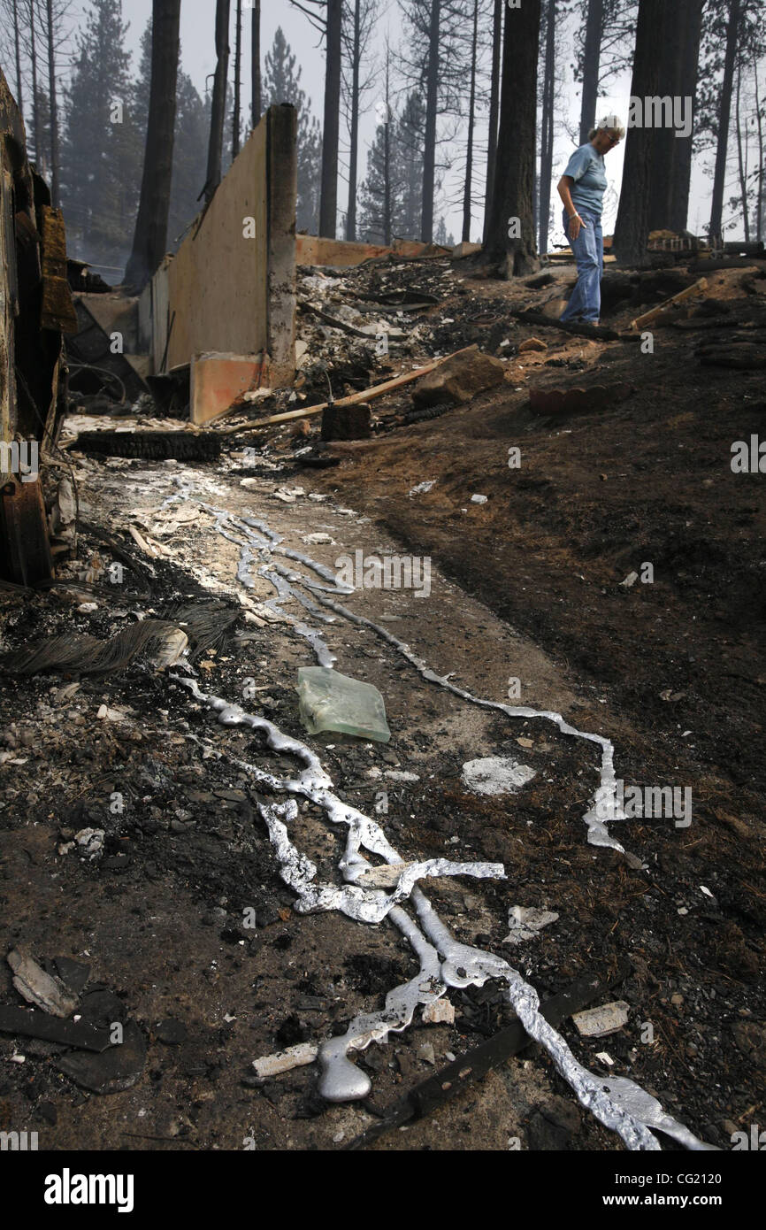 Didascalia ONLINE Missy Springer si aggira intorno ai resti della sua casa sull'Angora Creek Drive in South Lake Tahoe zona. In primo piano viene fuso i detriti dalla sua auto. Foto scattata al fuoco Angora Giugno 26, 2007. Sacramento Bee/Bryan Patrick Missy Springer si aggira intorno ai resti della sua ho Foto Stock