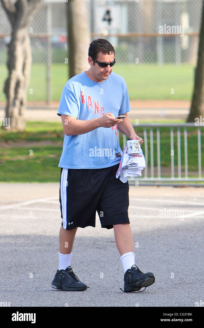 Adam Sandler utilizza il suo telefono cellulare in un gioco di basket in Brentwood. Los Angeles, California - 16.01.11 Foto Stock