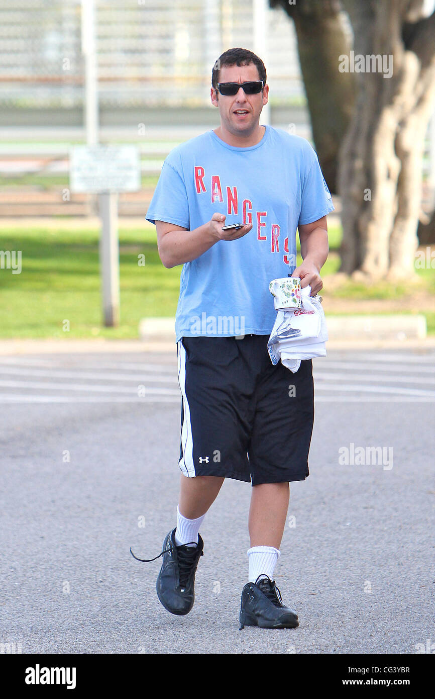 Adam Sandler utilizza il suo telefono cellulare in un gioco di basket in  Brentwood. Los Angeles, California - 16.01.11 Foto stock - Alamy