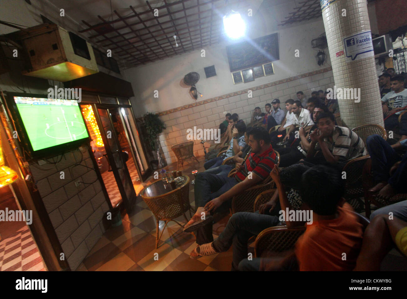 Agosto 23, 2012 - Gaza City, nella Striscia di Gaza, Territori palestinesi - giovani palestinesi guardare una partita di calcio per il FC Barcelona team contro il Real Madrid squadra durante una Supercoppa Spagnola presso il cafe a Deir al-Balah central nella Striscia di Gaza, il Ago 23, 2012 (credito Immagine: © Ashraf Amra/immagini APA/ZUMAPRESS.com) Foto Stock