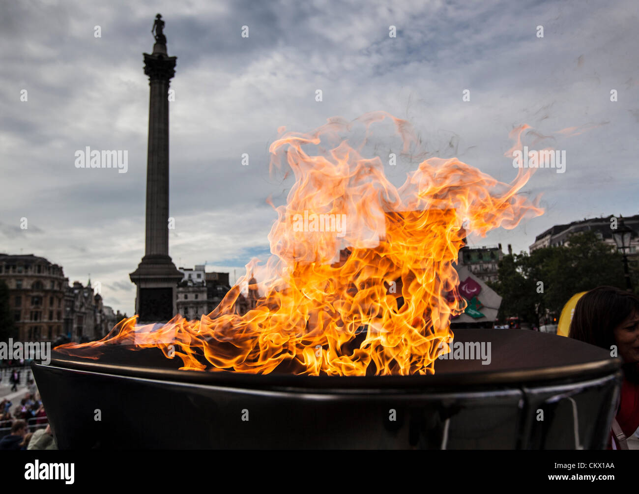 Londra, Regno Unito. Venerdì 24 agosto 2012. Il Paralympic fiamma brucia nel calderone in Trafalgar Square con Nelson's colonna in background. Foto Stock