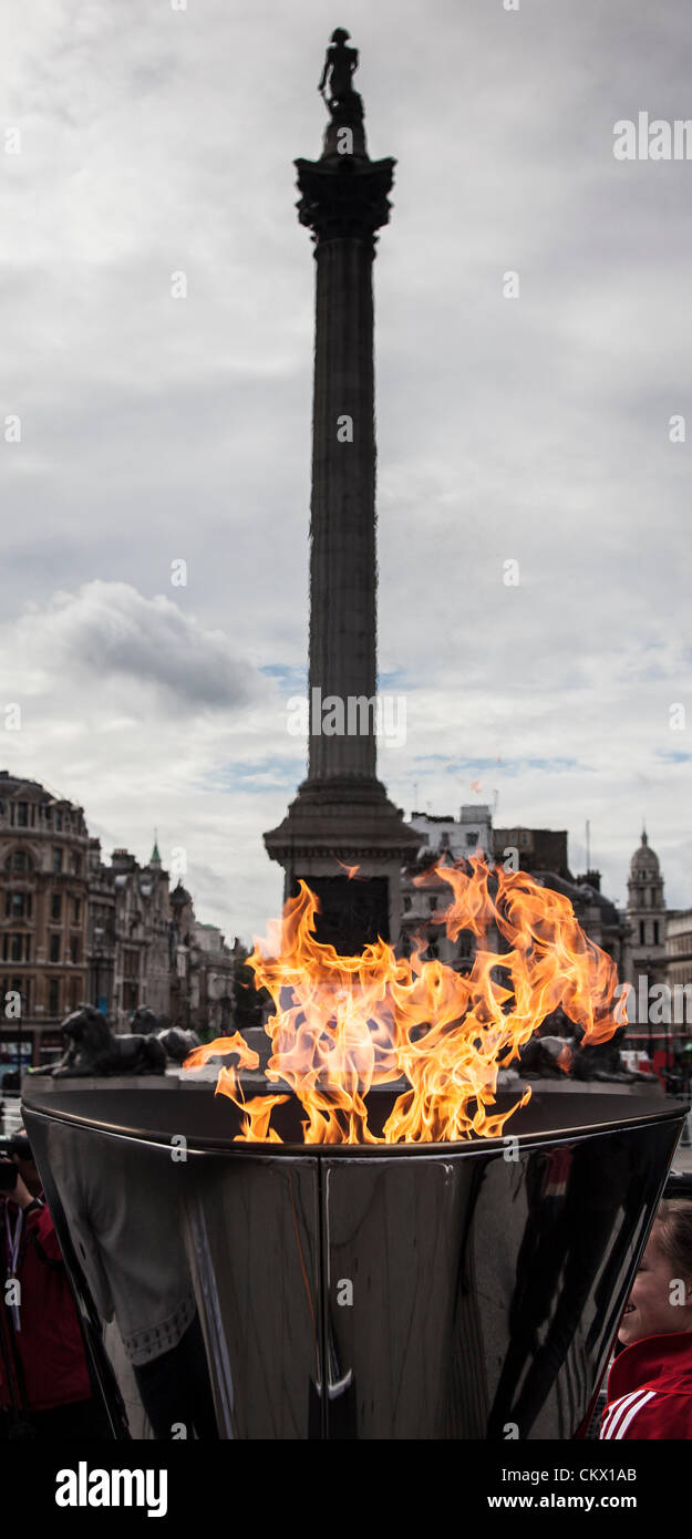 Londra, Regno Unito. Venerdì 24 agosto 2012. Il Paralympic fiamma brucia nel calderone in Trafalgar Square con Nelson's colonna in background. Foto Stock