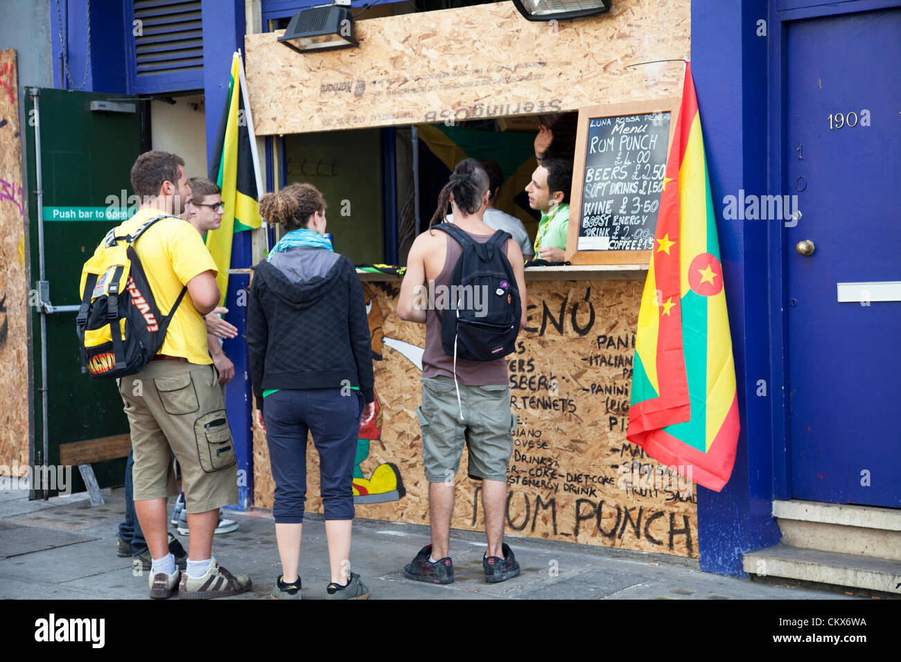 26 ago 2012, Domenica, Nottinghill Carnevale , Nottinghill Gate, London, Regno Unito - 10.05 h - festaioli raccogliere al di fuori di un rum punch e di stallo.. Credito: Miguel Sobreira / Alamy Live News Foto Stock