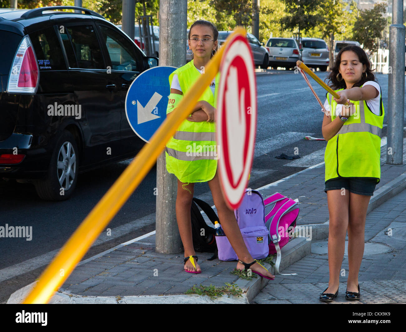 Il 27 agosto 2012. Sesto grado agli studenti di eseguire i servizi di monitoraggio del traffico e di assistere gli studenti più giovani in un accesso sicuro alla Yeffe-Nof scuola elementare. Gerusalemme, Israele. 27-Aug-2012. Bambini israeliani di tornare a scuola oggi, abolendo il tradizionale sett. 1a data, in una prima fase delle riforme avviate dal Ministero dell'istruzione mira ad accorciare le vacanze estive a 6 settimane, parzialmente alleviare i genitori di enormi spese finanziarie. Foto Stock