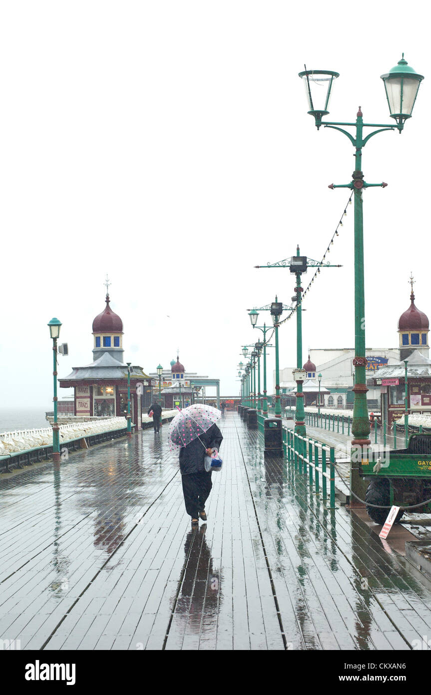 27 agosto 2012 bagnato e ventoso in Blackpool sulla la scorsa estate bank holiday dell anno ha mantenuto la vacanza lontano dalla folla. Donne combattendo il suo modo lungo North Pier. Credito: Kevin walsh Alamy / Live News Foto Stock