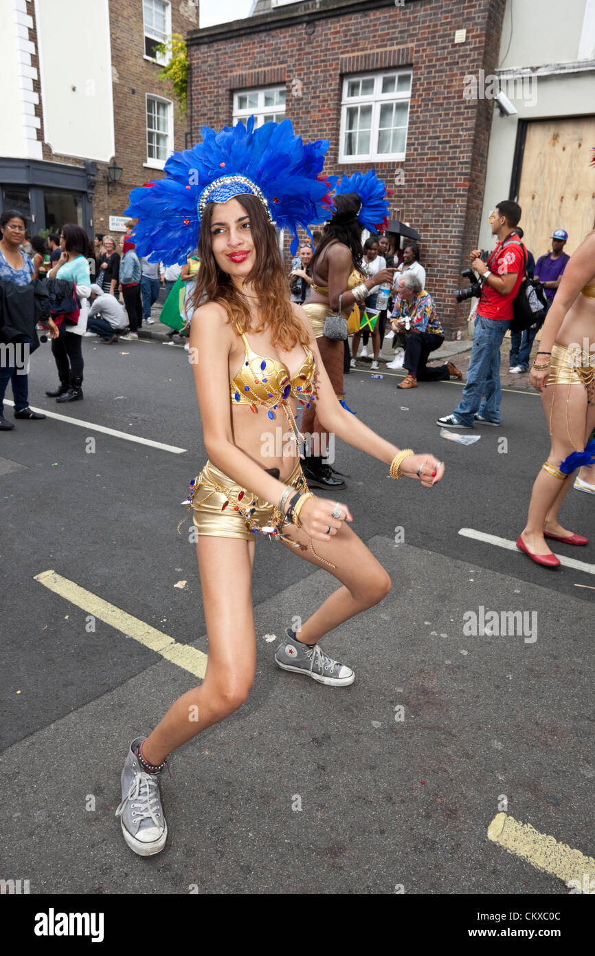 Ritratto a lunghezza intera di una giovane ballerina che si esibisce in un costume da skimpy, Notting Hill Carnival, Londra, Inghilterra, Regno Unito. Foto Stock