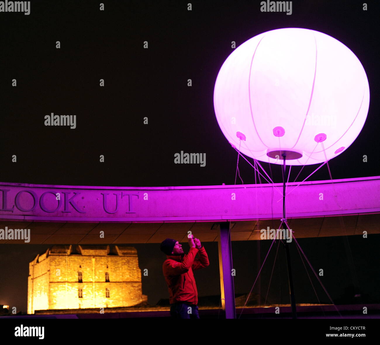 Carlisle, Regno Unito. Il 1 settembre 2012. La spia di collegamento installazione d arte da New York basata arti digitali YesYesNo collettiva. Alcuni 400 tempo palloncini con impulsi di luci LED colorate sono stati installati in vari siti attraverso i 73 chilometri di muro di Adriano. Qui un membro del pubblico viste una delle luci posizionata sulla rotonda a Tullie House Galleria d'arte e museo a Carlisle, Cumbria che insieme a Carlisle Castle si trova vicino alla linea del Muro di Adriano: 1 settembre 2012 STUART WALKER Foto Stock