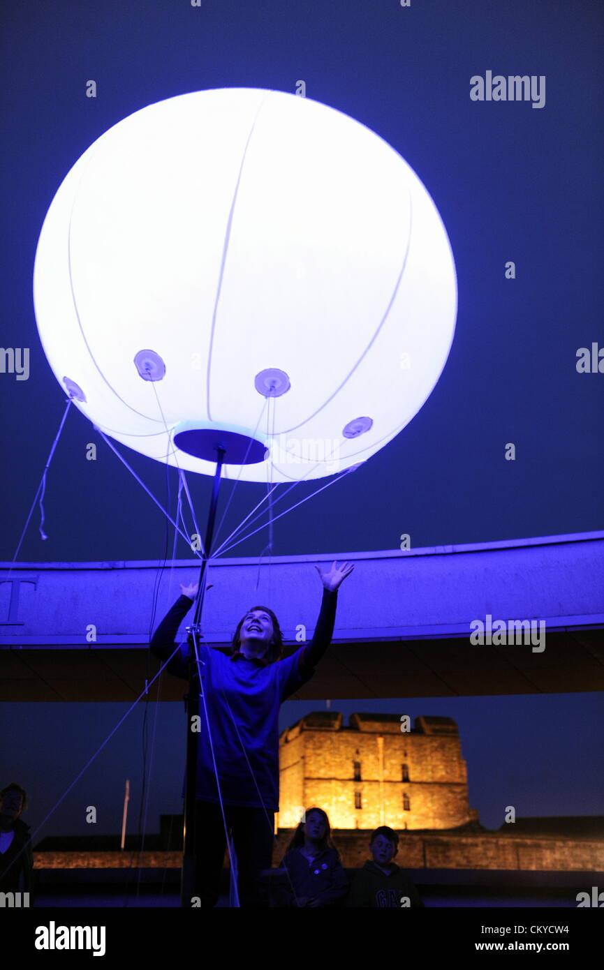 Carlisle, Regno Unito. Il 1 settembre 2012. La spia di collegamento installazione d arte da New York basata arti digitali YesYesNo collettiva. Alcuni 400 tempo palloncini con impulsi di luci LED colorate sono stati installati in vari siti attraverso i 73 chilometri di muro di Adriano. Qui un membro del pubblico viste una delle luci posizionata sulla rotonda a Tullie House Galleria d'arte e museo a Carlisle, Cumbria che insieme a Carlisle Castle si trova vicino alla linea del Muro di Adriano: 1 settembre 2012 STUART WALKER Foto Stock