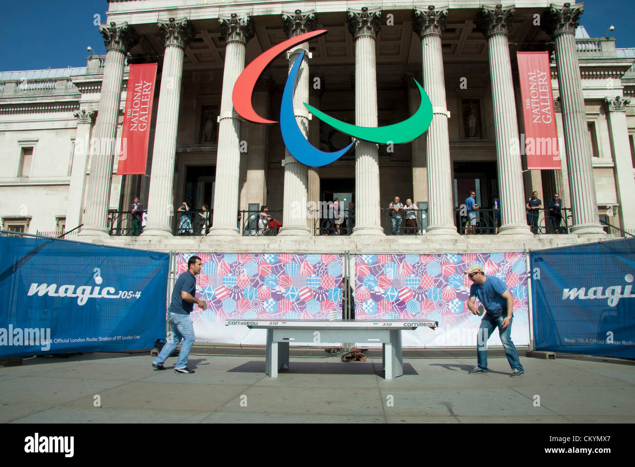 Londra, Regno Unito. Il 4 settembre, 2012. Londra REGNO UNITO. Gli uomini giocare a ping pong su tavoli liberi in Trafalgar Square come i Giochi Paralimpici sono mostrati su schermi giganti Foto Stock