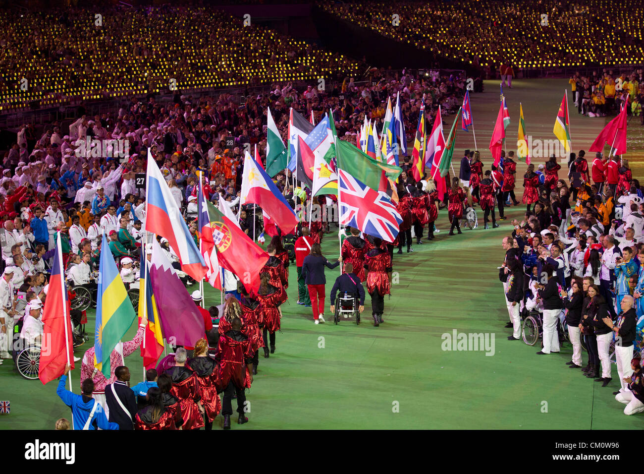Gli atleti a portare i loro paesi " Bandiere in stadio olimpico alla cerimonia di chiusura del 2012 Giochi Paralimpici di Londra Foto Stock