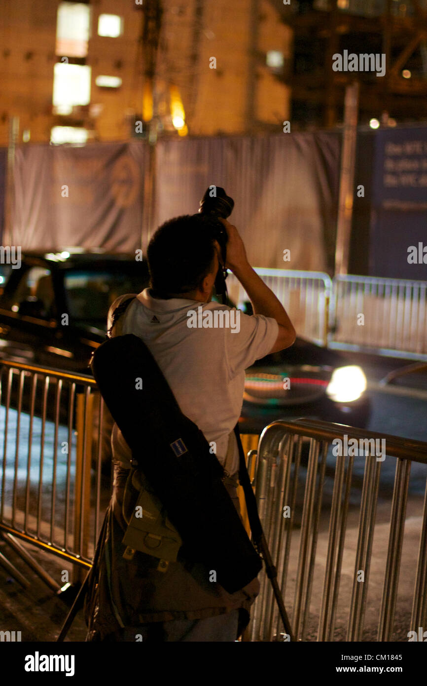 New York, NY - 11 Settembre 2012: persone a guardare fino al World Trade Center sito in costruzione come è acceso in rosso, bianco e blu nella memoria del 9/11 attacchi 11 anni prima. Foto Stock