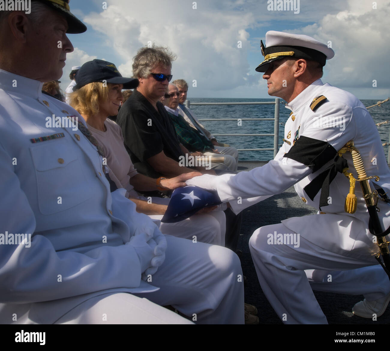 US Navy il capitano Steve Shinego, comandante della USS Philippine mare presenta la bandiera statunitense a Carol Armstrong dopo la sepoltura in mare servizio per suo marito Apollo 11 astronauta Neil Armstrong Settembre 14, 2012 a bordo della USS Mare delle Filippine nell'Oceano Atlantico. Armstrong, il primo uomo a camminare sulla luna durante il 1969 missione Apollo 11, morì il 25 agosto. Egli è stato 82. Foto Stock