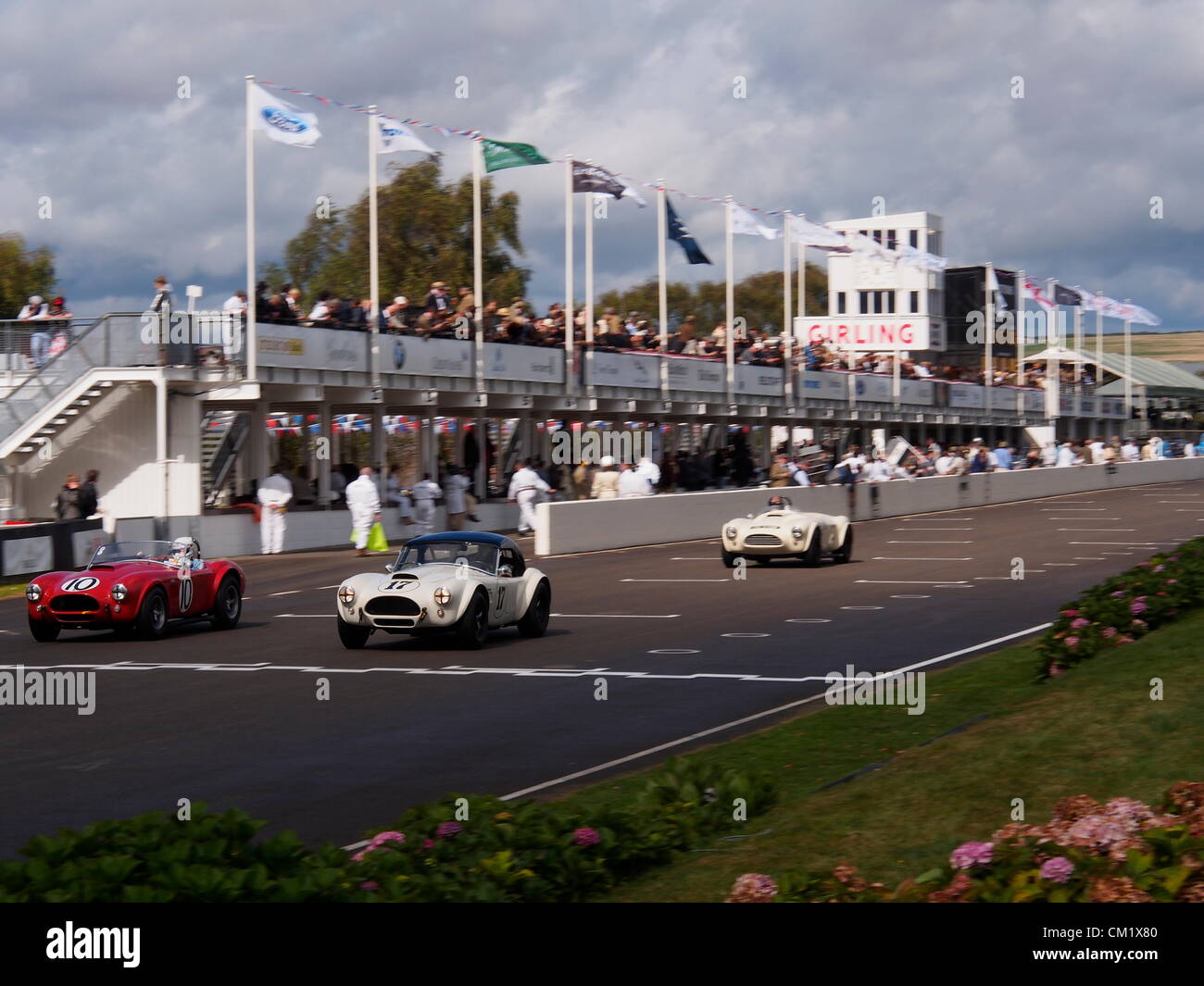 Goodwood pratica giorno Venerdì, Settembre 14th.2012. Tre corse del Cobra avvicinarsi al traguardo davanti ai box e guardando la folla in questa sede storica. Foto Stock