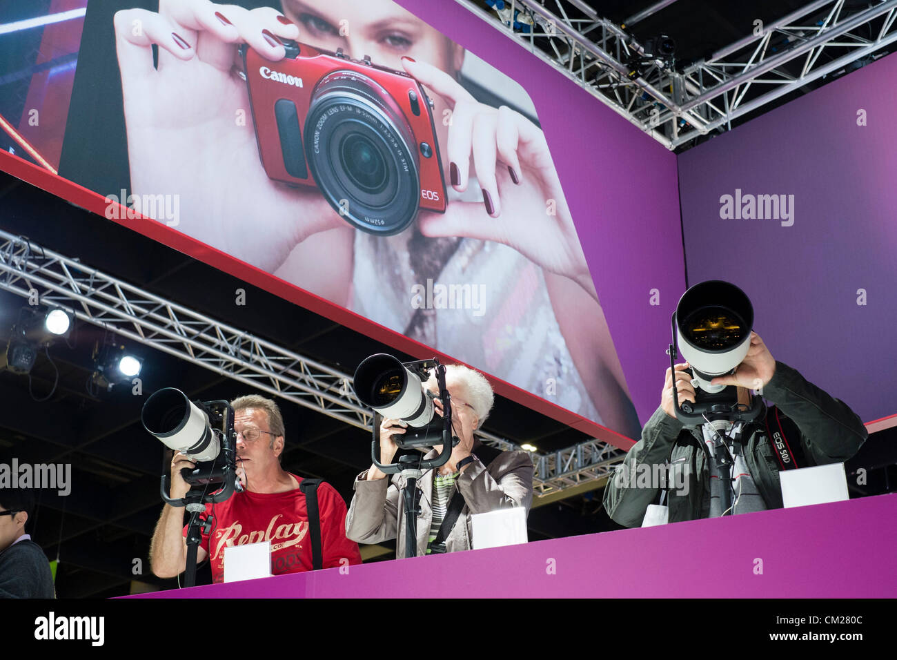 Colonia, Germania. I visitatori dello stand Canon provare una selezione di grandi teleobiettivi il giorno di apertura del bi-annuale di Photokina fotografia e immagini fiera che si svolge a Colonia Germania; Martedì 18 Settembre 2012 Foto Stock