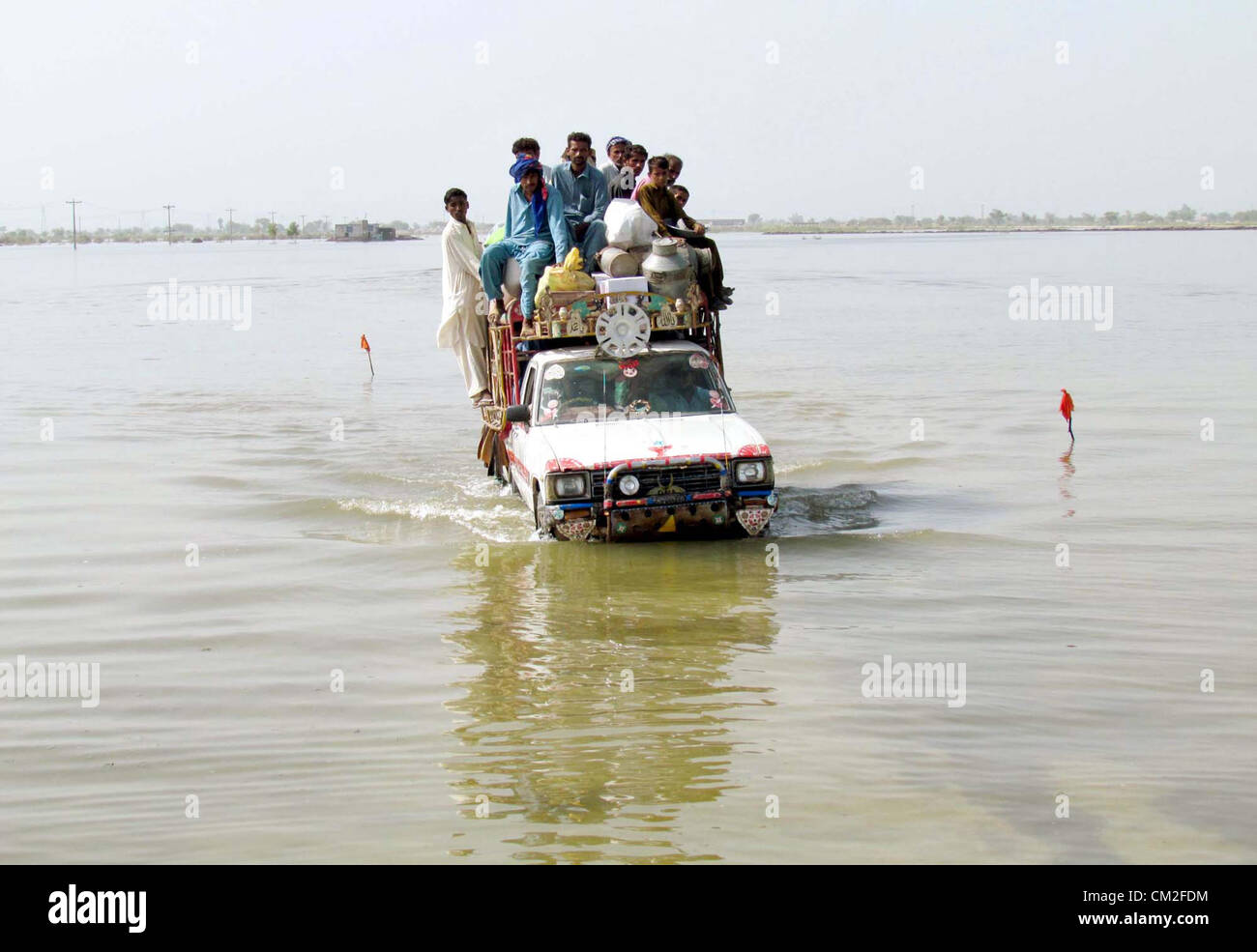 Colpite dalle alluvioni la gente si sposta verso il luogo sicuro dopo l'alluvione accumulata nelle loro case durante la pioggia pesante nella stagione dei monsoni a Jacobabad giovedì, 20 settembre 2012. Foto Stock