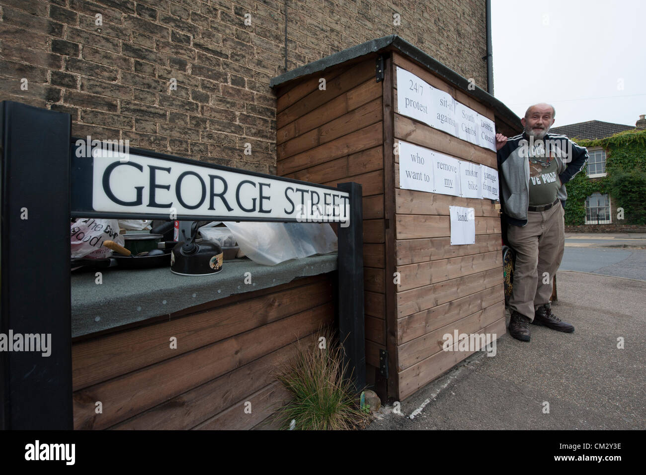 Steve Redman di Church Street Willingham vicino a Cambridge Regno Unito inizia a 24/7 sit-in, vivere nel suo capannone 23 settembre 2012. Ha trascorso un mese la costruzione della povera a motociclo garage su ciò che egli ritiene sia il suo paese, ma è stato chiesto di rimuoverlo, nonostante la proposta di relax nella pianificazione leggi, da South Cambridgeshire consiglio del distretto. Foto Stock