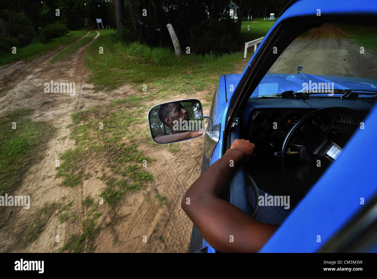 Agosto 23, 2012 - Sapelo Island, Ga, Stati Uniti d'America - ventuno-anno-vecchio Brandon Dixon aziona un pick-up truck attraverso la sporcizia strade di Hog amaca, giovedì 23 agosto 2012, su Sapelo Island, Ga. Le strade in Africa comunità Geechee-Gullah sono semplici strade sterrate senza segni di traffico, la marcatura o l'illuminazione. I proprietari si trovano di fronte a maggiori imposte e tasse da la contea di accertamento tributario, minacciando un già fragili comunità. (Credito Immagine: © Stephen Morton/ZUMAPRESS.com) Foto Stock