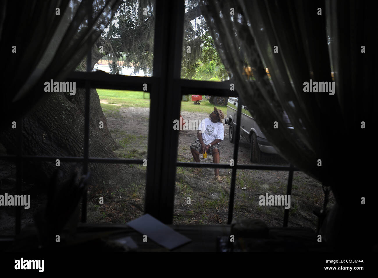 Agosto 23, 2012 - Sapelo Island, Ga, Stati Uniti d'America - Guardando per la pioggia Cornelia Bailey si siede nel cortile al di fuori del suo rimorchio-home in Geechee-Gullah comunità di Hog amaca, giovedì, Agosto 23, 2012 in su Sapelo Island, Ga. I proprietari si trovano di fronte a maggiori imposte e tasse da la contea di accertamento tributario, minacciando un già fragili comunità. Bailey è in grado di tracciare la sua famiglia il patrimonio torna alla schiavitù prima della guerra civile. (Credito Immagine: © Stephen Morton/ZUMAPRESS.com) Foto Stock