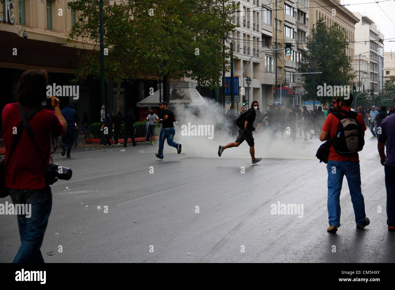 Atene, Grecia. 9 ottobre 2012. Un gas lacrimogeni bomba esplode tra i manifestanti. Violenti scontri hanno avuto luogo nel corso di un anti-Merkel in segno di protesta come il Cancelliere tedesco ha visitato Atene del 9 ottobre 2012. Foto Stock