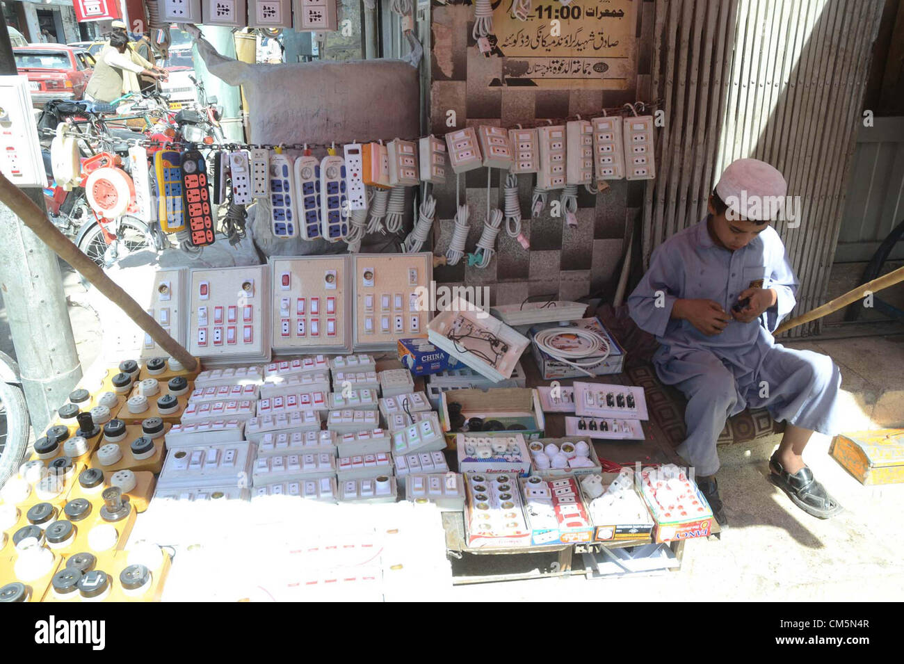 Bambino vende apparecchiature elettriche oggetti usati per guadagnare i propri mezzi di sostentamento per sostenere la sua famiglia a uno stallo stradale a Quetta Mercoledì, Ottobre 10, 2012. Foto Stock