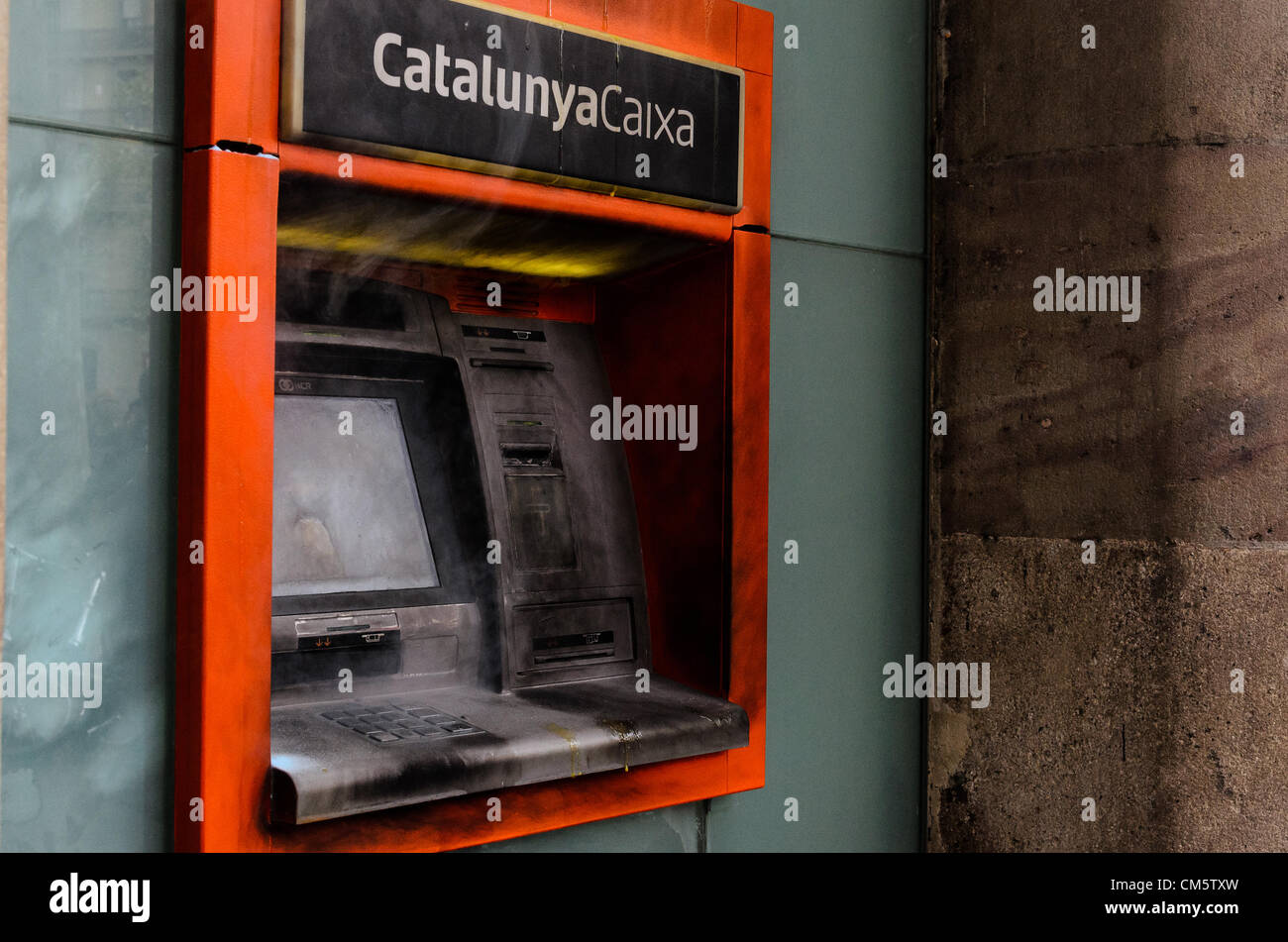 Barcellona, Spagna. 11 ottobre 2012. Un terminale di cassa della Catalunya Caixa Bank è bruciato durante una dimostrazione degli studenti contro i tagli di austerità e privatozation nel settore educativo. Foto Stock