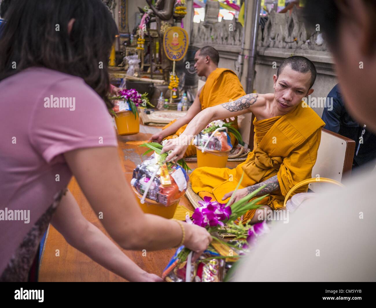 Ottobre 12, 2012 - Rai Khring, Nakhon Pathom, Thailandia - Sono le persone a fare offerte per i monaci di rendere merito durante un canto servizio al Wat Rai Khring nella provincia di Nakhon Pathom. Wat Khring Rai è stato costruito nel 1791. L'Abate al momento, Somdej Phra Phuttha Chan (Pook), chiamato il tempio dopo il distretto. Quando la costruzione è stata completata, l'immagine del Buddha è stato portato da un altro tempio e sancito qui. Più tardi la gente del luogo denominato l'immagine â€oeLuang Wat Pho Rai Khingâ€. Le immagini del Buddha di Chiang Saen stile e si presume sia stata costruita da Lanna Thai e Lan Chang artigiani. (Credito Immagine: © Jack K Foto Stock