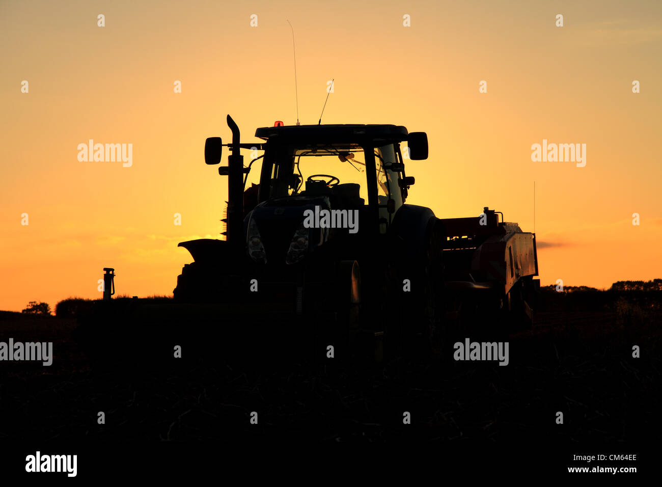 Un New Holland T7040 il trattore e un Grimme GT300 patata trainato harvester park up & fine la loro lunga giornata combattendo contro il terreno impregnato d'acqua. I campi umidi sono rendendo difficile per gli agricoltori del Regno Unito per completare il loro raccolto. Credito: Paolo Lilley/Digitalshot.co.uk / Alamy Foto Stock