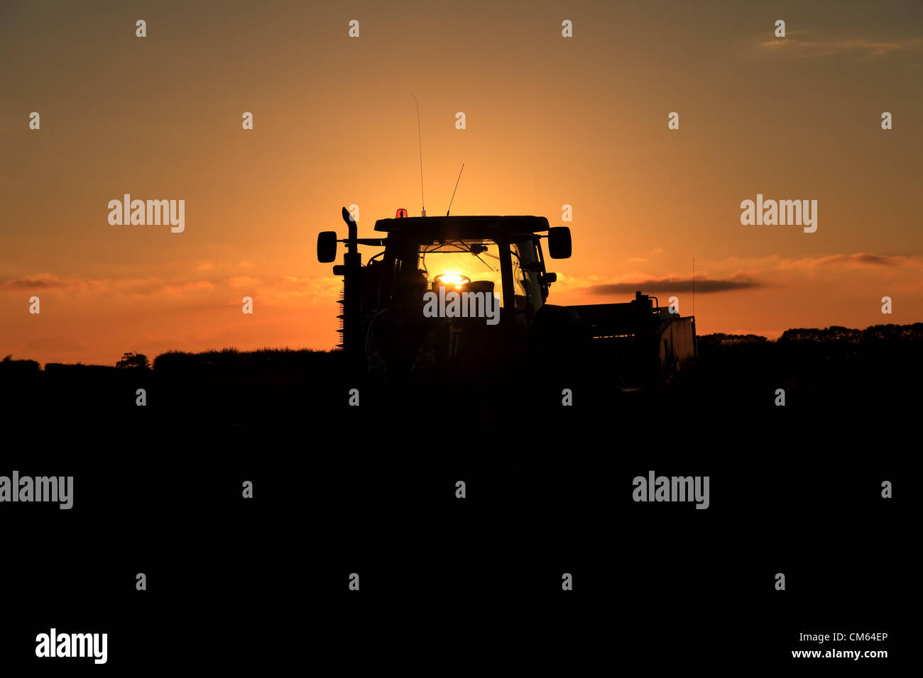 Un New Holland T7040 il trattore e un Grimme GT300 patata trainato harvester park up & fine la loro lunga giornata combattendo contro il terreno impregnato d'acqua. I campi umidi sono rendendo difficile per gli agricoltori del Regno Unito per completare il loro raccolto. Credito: Paolo Lilley/Digitalshot.co.uk / Alamy Foto Stock