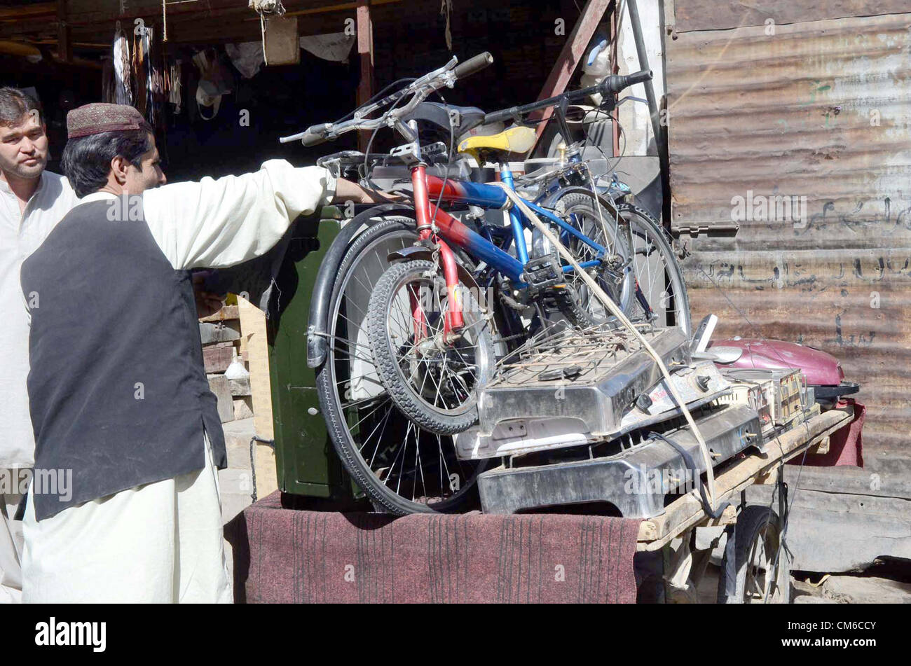 Un uomo vende diversi oggetti usati per guadagnare i propri mezzi di sostentamento per sostenere la sua famiglia sul suo push-carrello a Quetta Lunedì 15 Ottobre, 2012. Foto Stock