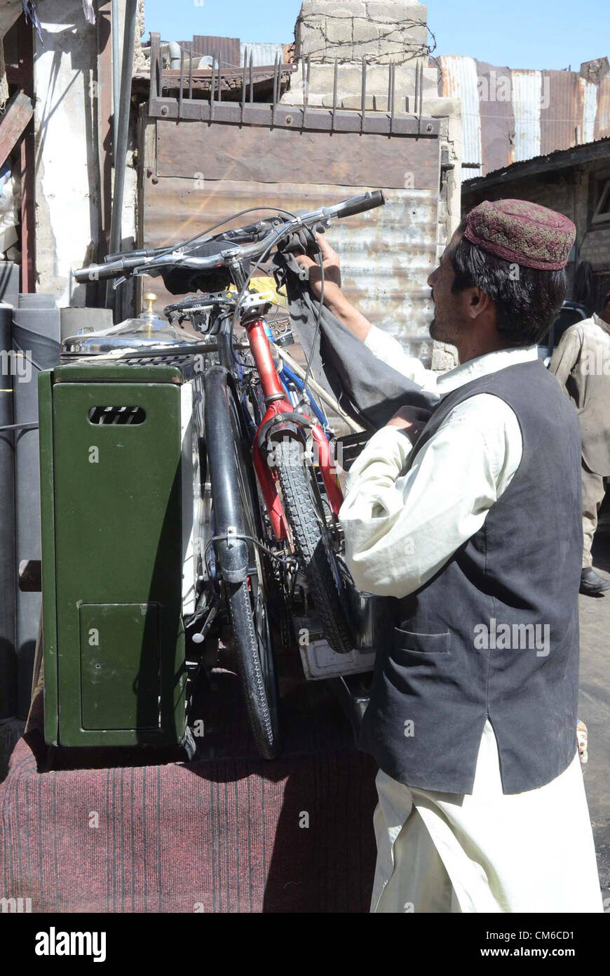 Un uomo vende diversi oggetti usati per guadagnare i propri mezzi di sostentamento per sostenere la sua famiglia sul suo push-carrello a Quetta Lunedì 15 Ottobre, 2012. Foto Stock