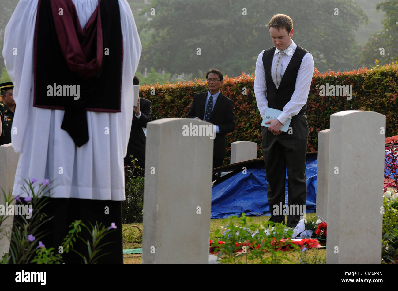 Kuala Lumpur, Malesia. 18 ottobre, 2012. I membri della famiglia, militari britannici, e l'alto commissario britannico di pagare i loro ultimi rispetto durante la sepoltura di otto RAF Membri di equipaggio al Commonwealth War Cemetery a Kuala Lumpur. Gli otto membri di equipaggio sono stati battenti un B-24 Liberator su agosto 23, 1945, otto giorni dopo il giappone si arrese durante la II Guerra Mondiale, quando l'aereo si è schiantato ed è stato perso vicino a Kuala Pilah, Malaysia. Foto Stock