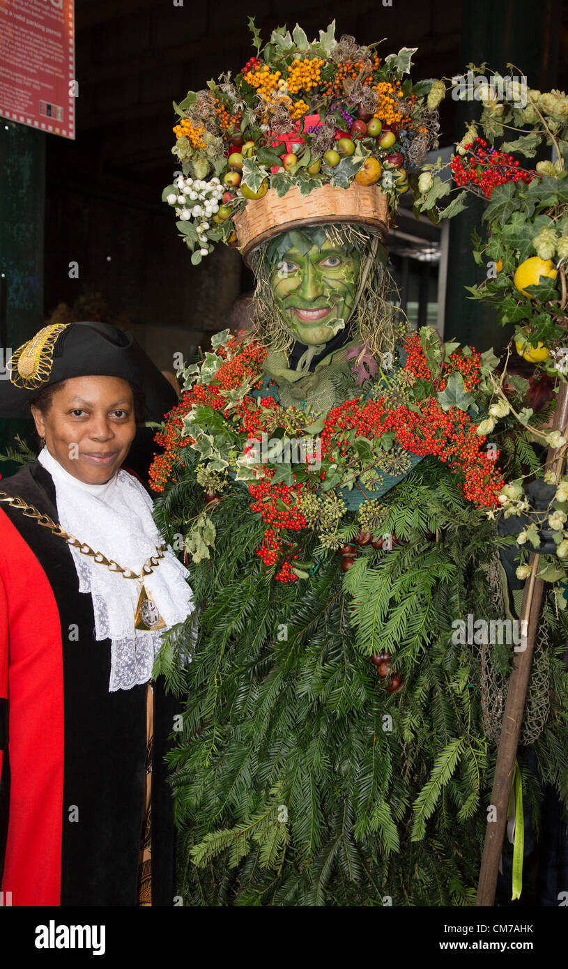 Nella foto: Consigliere Althea Smith, il Sindaco di Southwark con la "Green Man'. Borough Market ha aperto le sue porte di domenica 21 ottobre, per il mercato annuale di Apple 'giorno' dell'evento. In questa festa della mietitura celebrazione, i visitatori hanno avuto la possibilità di assaggiare le varietà di mele e prodotti. Foto Stock