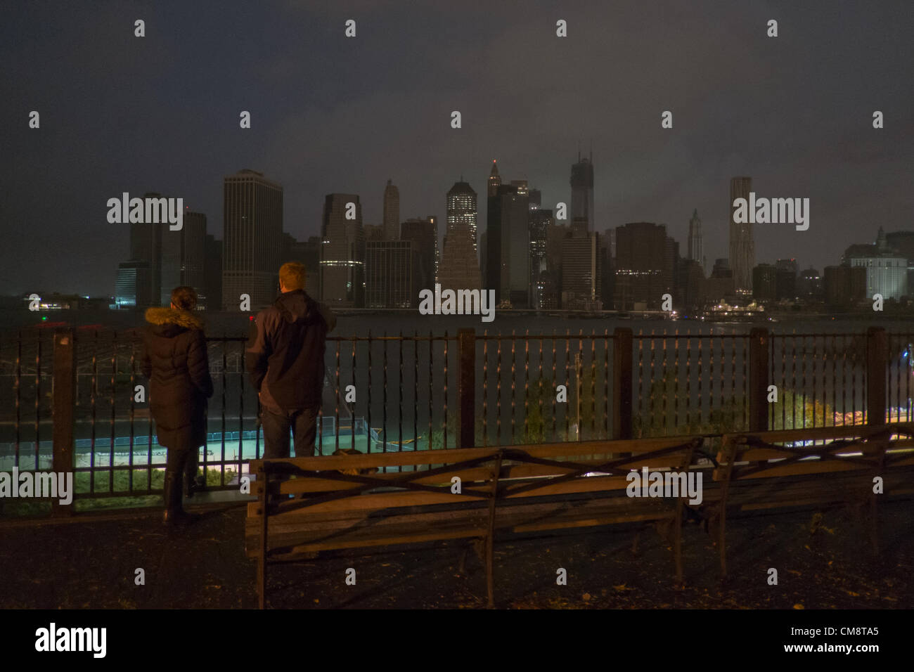 Ottobre 29, 2012, Brooklyn, NY, Stati Uniti. La gente sulla Passeggiata di Brooklyn Heights guardare al buio di una skyline di Manhattan dopo l uragano Sandy tagliate elettricità a parti di Manhattan. Foto Stock