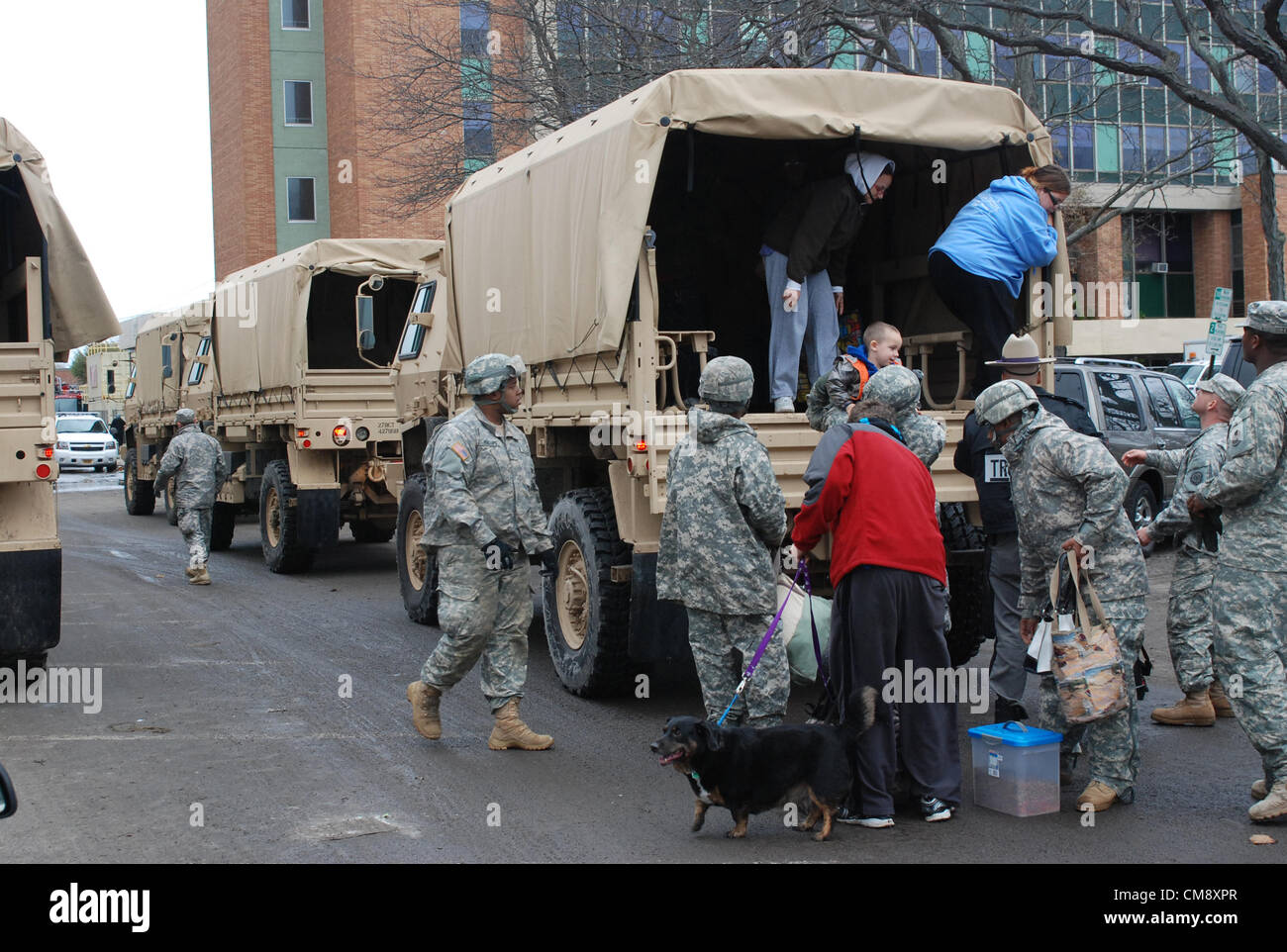 LONG BEACH, N.Y. - New York Esercito Nazionale soldati di guardia dalla società F, 427th brigata battaglione supporto assistere i residenti locali che arrivano da un veicolo militare a Long Beach City Hall per evacuazione ai ripari supervisionato da Nassau County Office nella gestione delle situazioni di emergenza. La Guardia Nazionale Forza di risposta è parte del governatore Cuomo's callup di più di 2.200 truppe in risposta alla tempesta subtropicale Sandy che ha colpito la città di New York e Long Island ott. 29. La Guardia Nazionale è stato il supporto locale di soccorritori di emergenza in ed intorno a lungo Credito: New York Nazione guardia/immagine di archivio Foto Stock