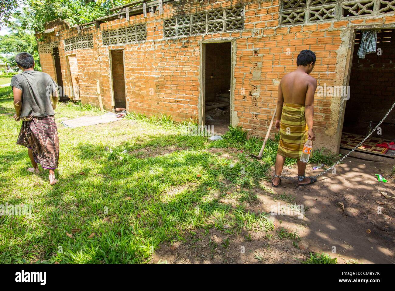 Ottobre 29, 2012 - Mayo, Pattani, Tailandia - un fiduciario passa un residente in manette in Bukit Kong home in Mayo. La casa ha aperto 27 anni fa come una scuola Pondo, o tradizionale scuola islamica, nel Mayo quartiere di Pattani. Poco dopo la sua apertura, la gente ha chiesto al preside di occuparsi di individui con la malattia mentale. (Credito Immagine: © Jack Kurtz/ZUMAPRESS.com) Foto Stock