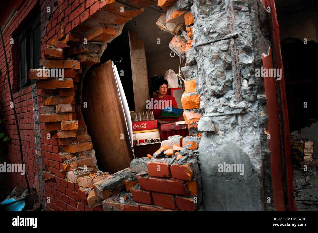 Giugno 30, 2012 - Kathmandu, Nepal - Una donna rimuove inventario dal suo negozio dopo un bulldozer ha abbattuto le sue pareti su Lazimpat road dove il governo sta abbattendo edifici condannato come illegale. Otto manifestanti sono stati brevemente incarcerati prima della demolizione ha continuato come parte di un piano per allargare le strade. Alcuni 318 edifici sono stati demoliti e per la maggior parte non vi sarà alcuna compensazione finanziaria. (Credito Immagine: © Agron Dragaj/ZUMAPRESS.com) Foto Stock