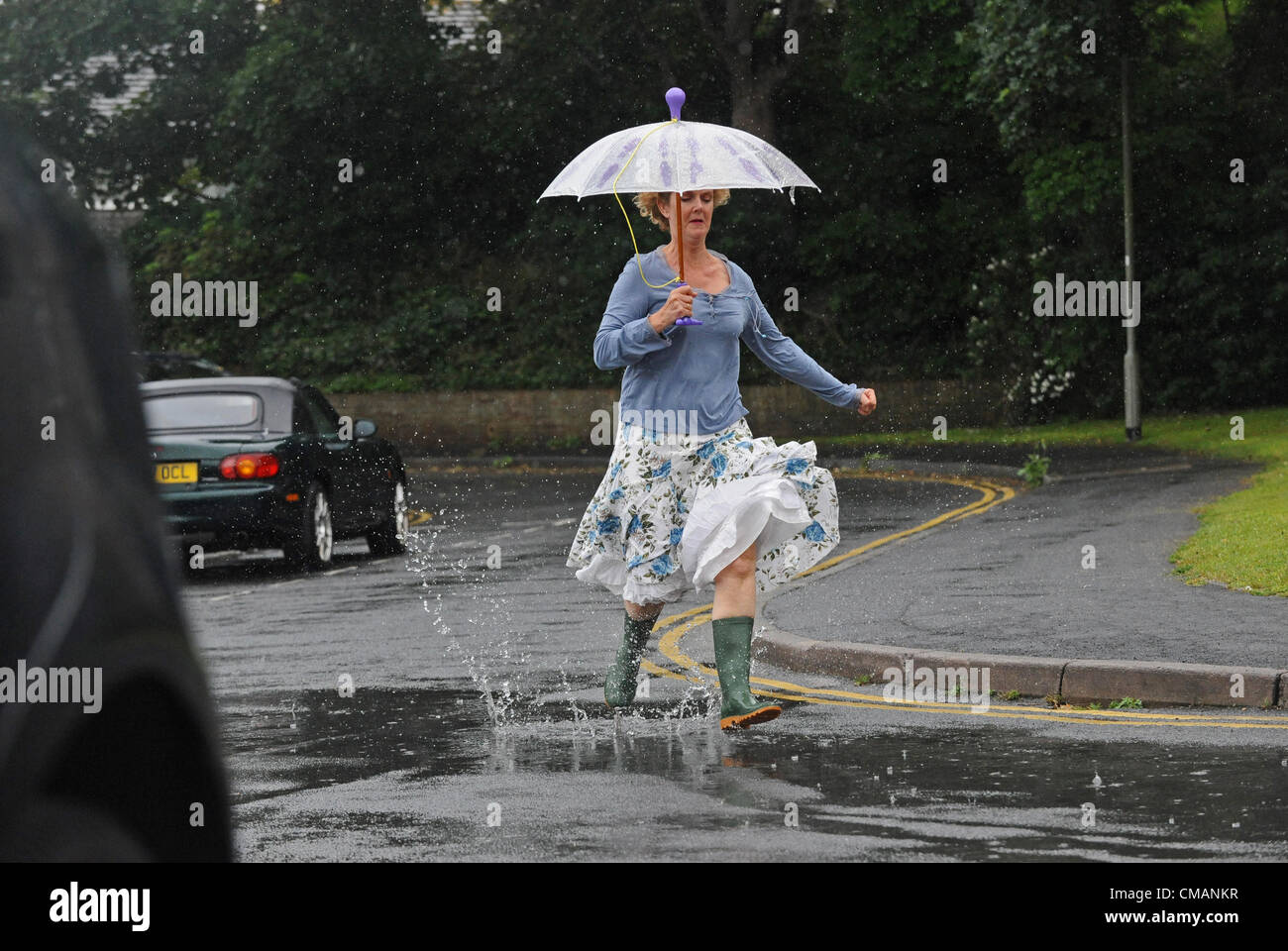 Brighton Regno Unito 6 Luglio 2012 - Una donna rende un trattino per it con un ombrello come lei corre attraverso heavy rain in Brighton questa mattina Foto Stock