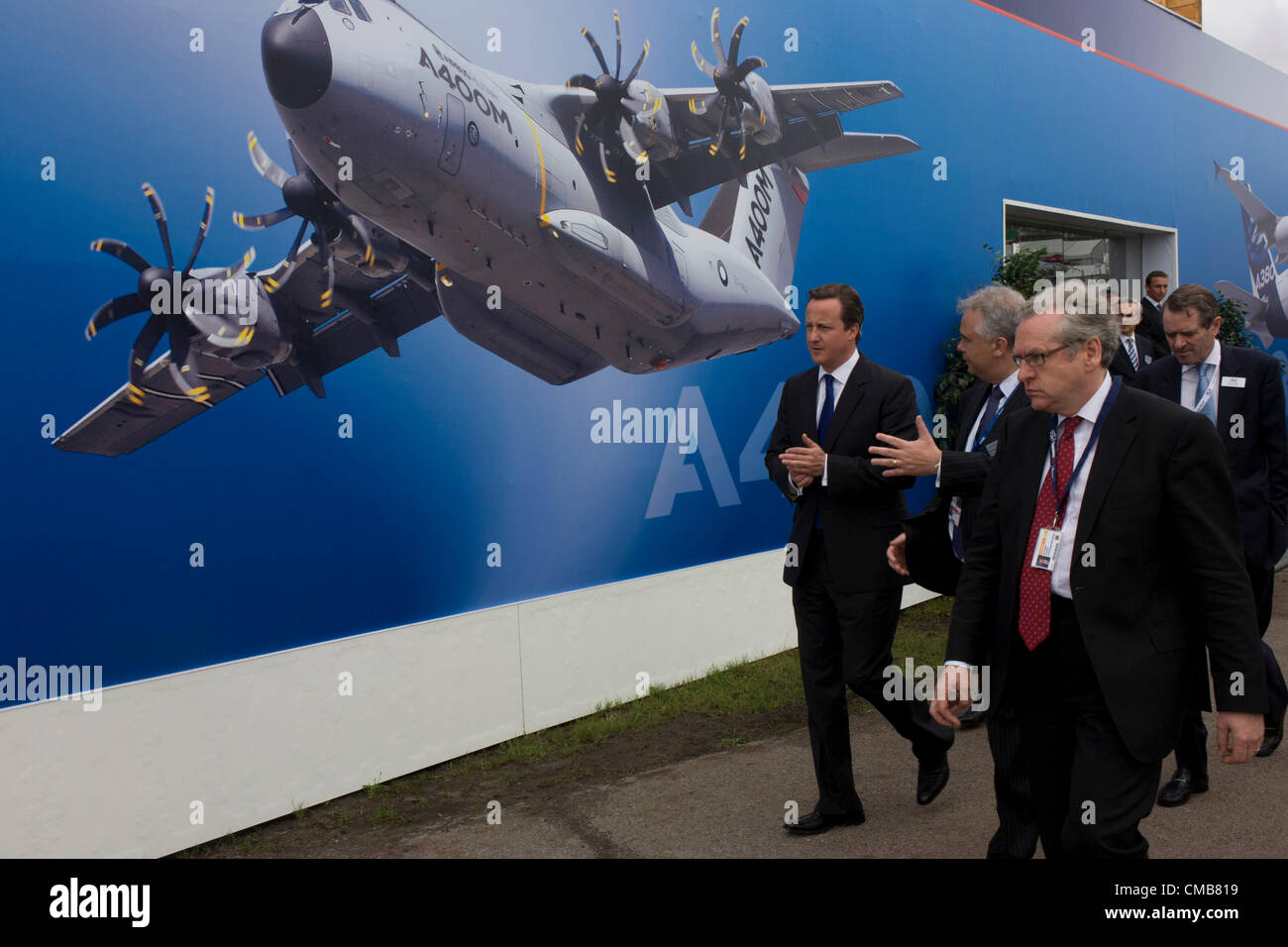 Farnborough, Regno Unito 09/07/12 del primo ministro britannico David Cameron passeggiate passato uno degli Airbus stand espositivi al salone di Farnborough, Inghilterra. Contribuendo al lancio di questa Expo che si terrà per la navigazione aerea internazionale e aerospaziale, Cameron ha girato sta per contribuire a promuovere gli scambi commerciali e gli investimenti per questo 48th (airshow FIA)e salutato il fenomenale successo del Regno Unito industria aerospaziale e la sua fondamentale importanza per la crescita e l'occupazione. Farnborough è frequentato da un commercio internazionale pubblico compresi 83 Commercio e delegazioni militari provenienti da oltre 43 paesi. Foto Stock