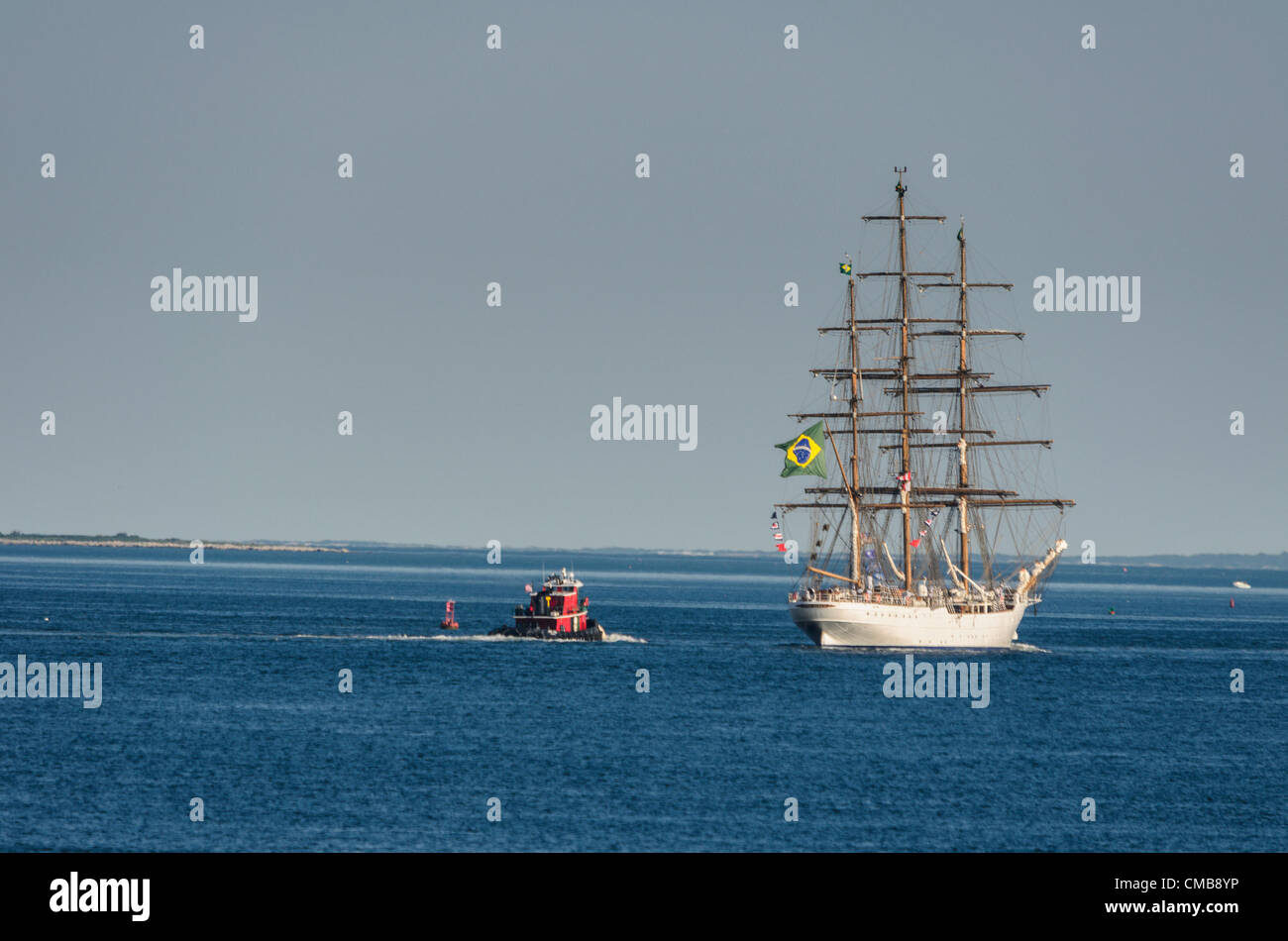 New London, Connecticut, Stati Uniti d'America - 9 Luglio 2012: il brasiliano tall ship Cisne Branco con indicatori di segnale e la bandiera del Brasile battenti, vele lontano da Fort Trumbull verso casa con in rosso di un rimorchiatore a traino dietro di esso come OpSail 2012, per commemorare il bicentenario della guerra del 1812 e penning della US National Anthem, la stella Lamas Banner volge al termine. Foto Stock