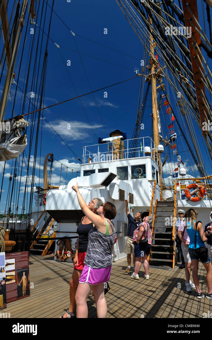 New London, Connecticut, Stati Uniti d'America - 9 Luglio 2012: Susan Roberts, formalmente di Chippenham, Wiltshire, Inghilterra e ora di West Hartford Connecticut e sua figlia Laura Doten esplorare la US Coast Guard Eagle della nave nel porto di Fort Trumbull durante OpSail 2012 CT, celebra il bicentenario della guerra del 1812 e penning della stella Lamas Banner, gli Stati Uniti inno nazionale. Foto Stock